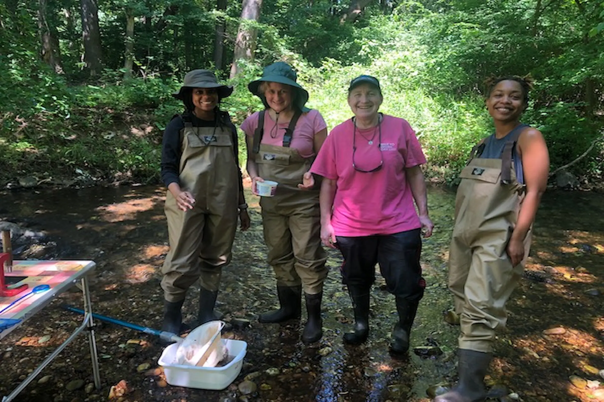 image shows people standing in the woods dressed in waders