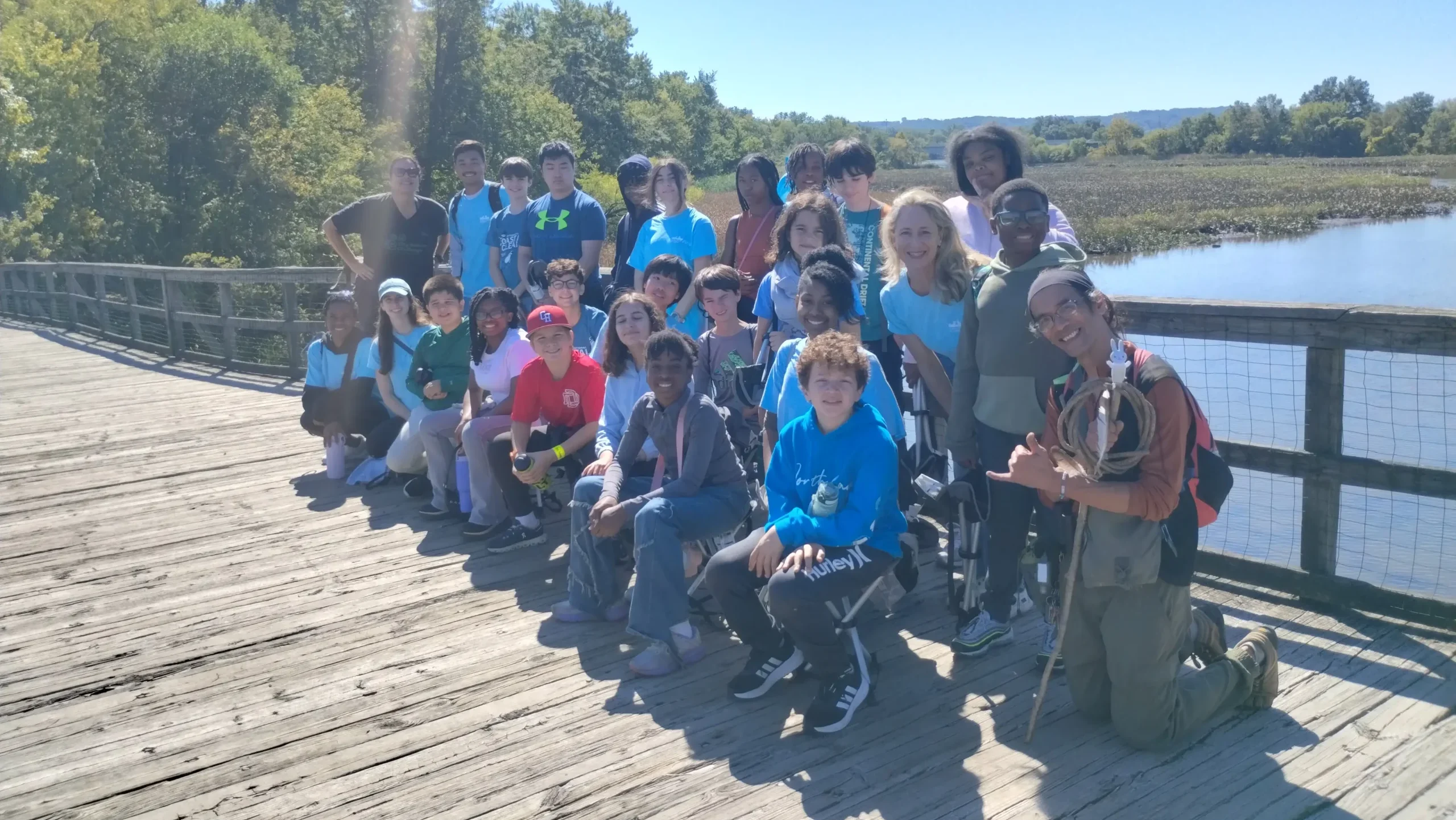 children and educator standing on a boating dock