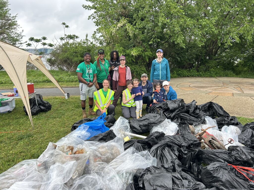group of people with bags of trash in the foreground